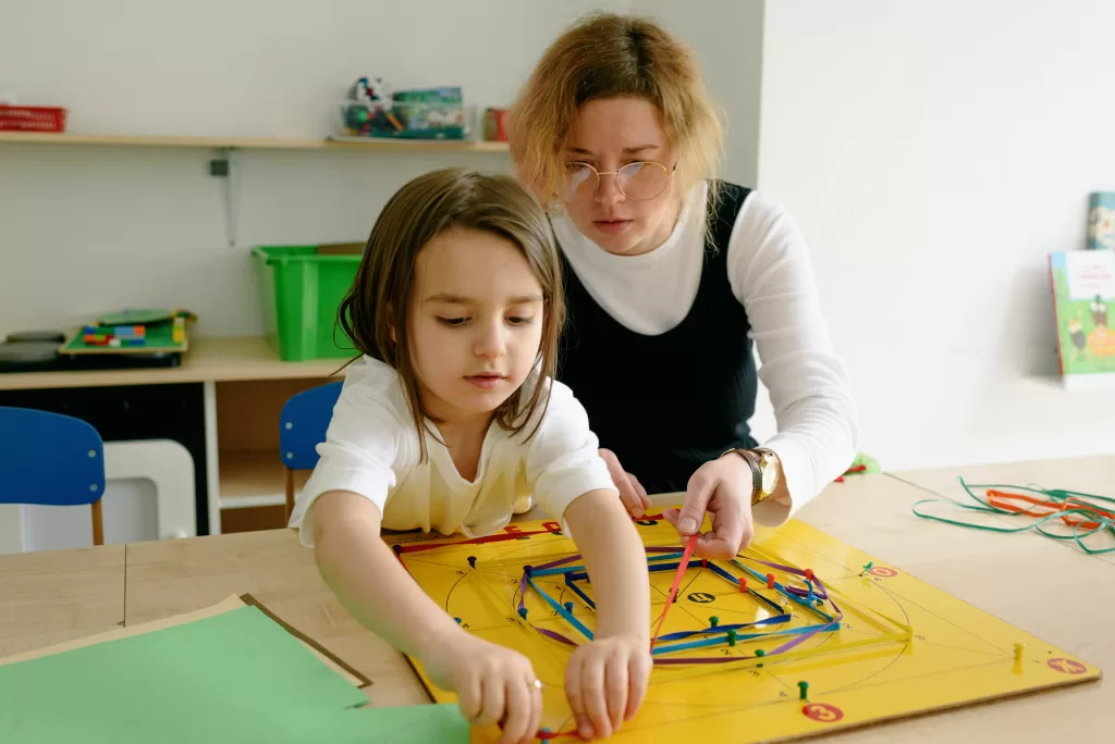A mother and child playing a game together in a playroom.